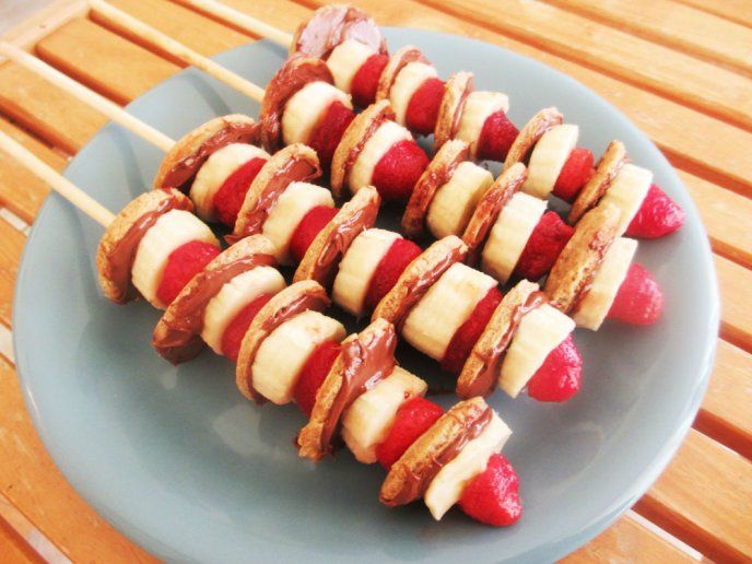 some food is on a blue plate with strawberries and other foods are arranged around it