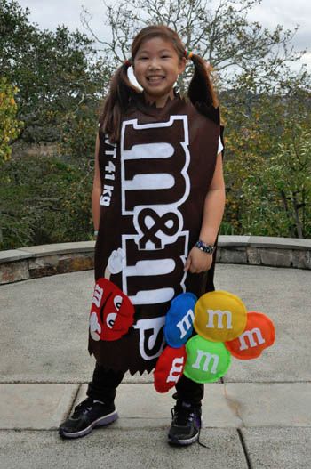 a girl is standing on the sidewalk with balloons in front of her and smiling at the camera