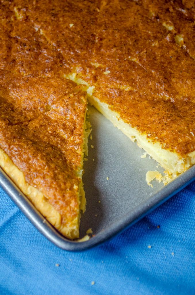 a cake that has been cut in half on a metal pan with a blue cloth