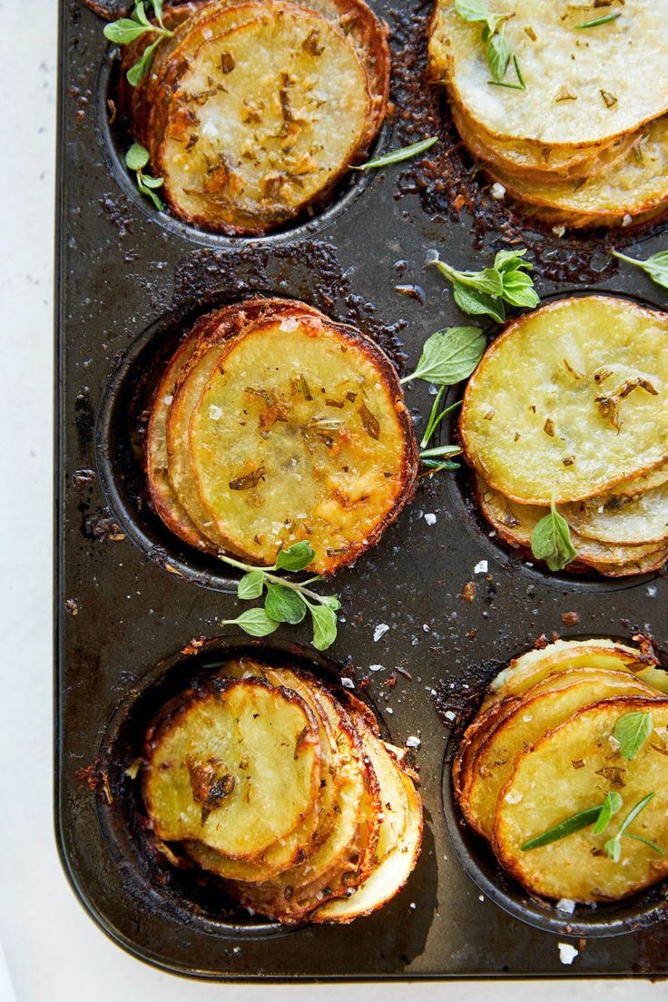 baked potatoes with herbs and seasoning in a muffin tin