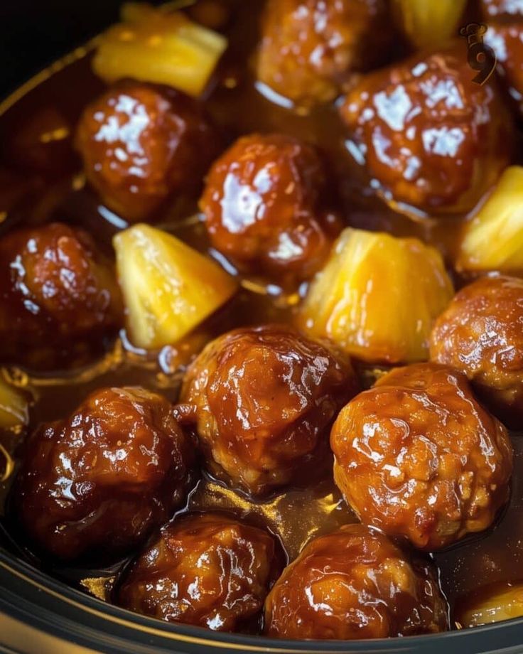 meatballs and pineapples are cooked in the crock pot with brown sauce