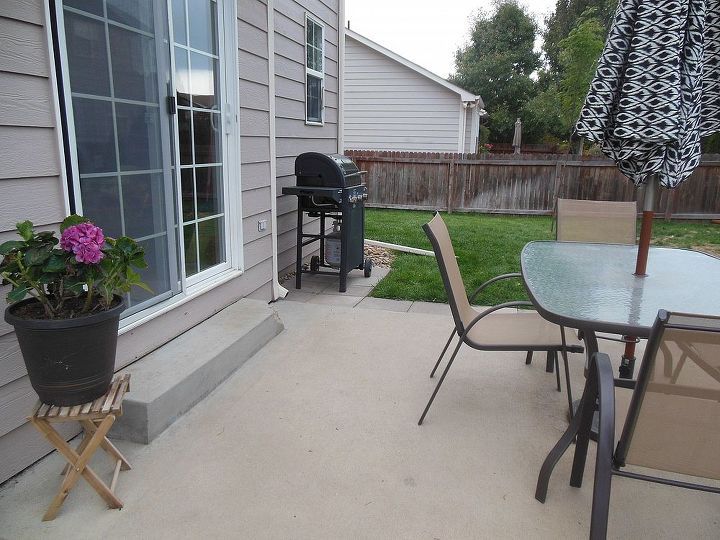 an outdoor patio with table and chairs next to a bbq in the back yard