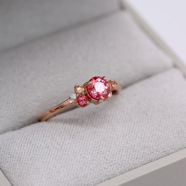 The padparadscha sapphire cluster ring is an expression of pure joy. She gathers created sapphires of varying pink hues and brilliant white lab-created diamonds together into an asymmetrical, sparkling bouquet. At once delicate and intense, this gemstone ring makes the perfect right-hand ring or alternative engagement ring. Details: 14k rose gold .66ct padparadscha created sapphire center .02 total carat weight - lab-grown diamonds .81 total carat weight - created sapphires Pink Ruby Birthstone Ring For Wedding, Pink Cluster Promise Ring In Fine Jewelry Style, Pink Diamond Cluster Ring With Accent Stones, Pink Ruby Ring For Proposal In Fine Jewelry Style, Pink Ruby Ring With Accent Stones For Promise, Pink Sapphire Diamond Ring With Round Cut, Pink Cluster Diamond Ring For Wedding, Pink Cluster Diamond Ring, Pink Diamond Birthstone Ring For Promise