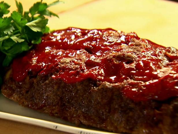 a piece of steak covered in ketchup and garnished with parsley