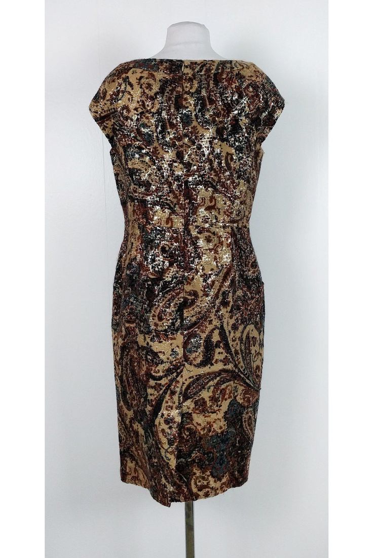 This elegant dress has a gorgeous print with metallic gold threads. Dress it up or dress it down, this dress is bound to wow. Size 10 87% wool, 7% polyester, 6% silk Rounded neckline Back zipper Cap sleeves Back slits Embroidered fabric Metallic gold threads Bust 38" Waist 34" Shoulder to hem 41.75" Brown Knee-length Midi Dress For Parties, Gold Sequin Midi Dress For Formal Occasions, Formal Gold Sequin Midi Dress, Formal Brown Silk Midi Dress, Fitted Brown Midi Dress For Party, Brown Silk Midi Dress For Party, Party Brown Silk Midi Dress, Fitted Gold Midi Dress For Fall, Brown Knee-length Party Dress