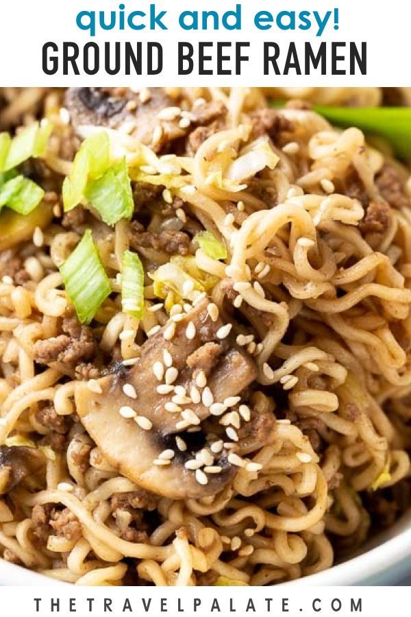 a bowl filled with beef and noodles, topped with sesame seed sprinkles