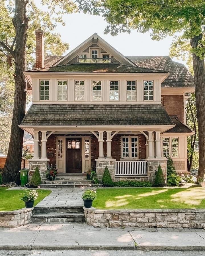 a large house with lots of windows in the front yard and steps leading up to it