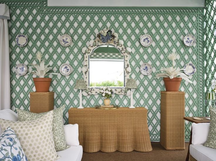 a living room with green and white wallpaper, two couches and a mirror on the wall