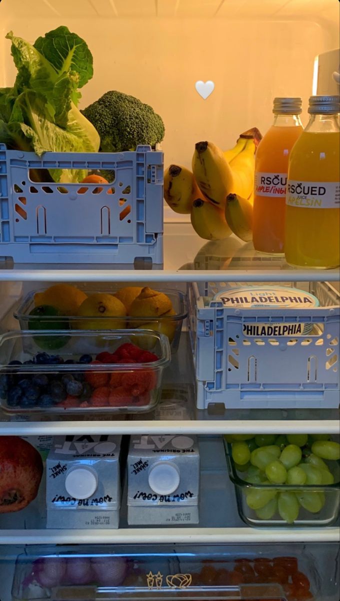 an open refrigerator filled with lots of different types of fruits and veggies in containers