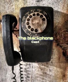 an old black phone is on the wall