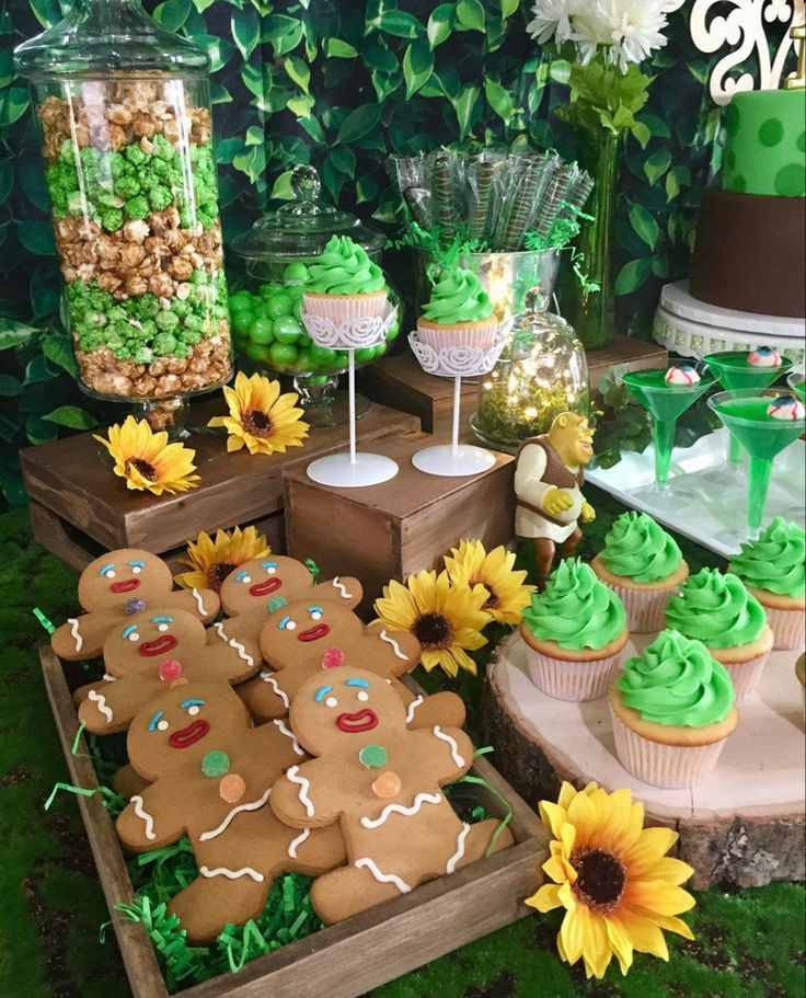 a table with cupcakes, cookies and sunflowers on top of it