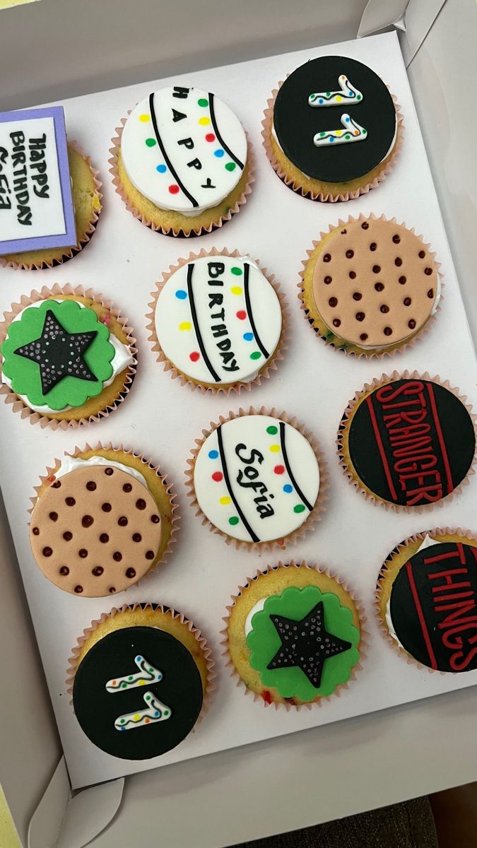 a box filled with decorated cupcakes sitting on top of a table