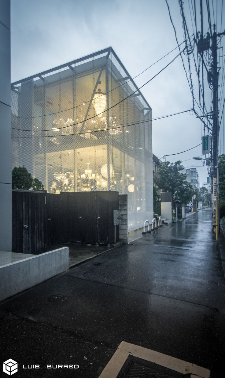 an empty street in the rain next to a building