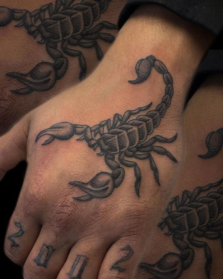 two hands with scorpion tattoos on them