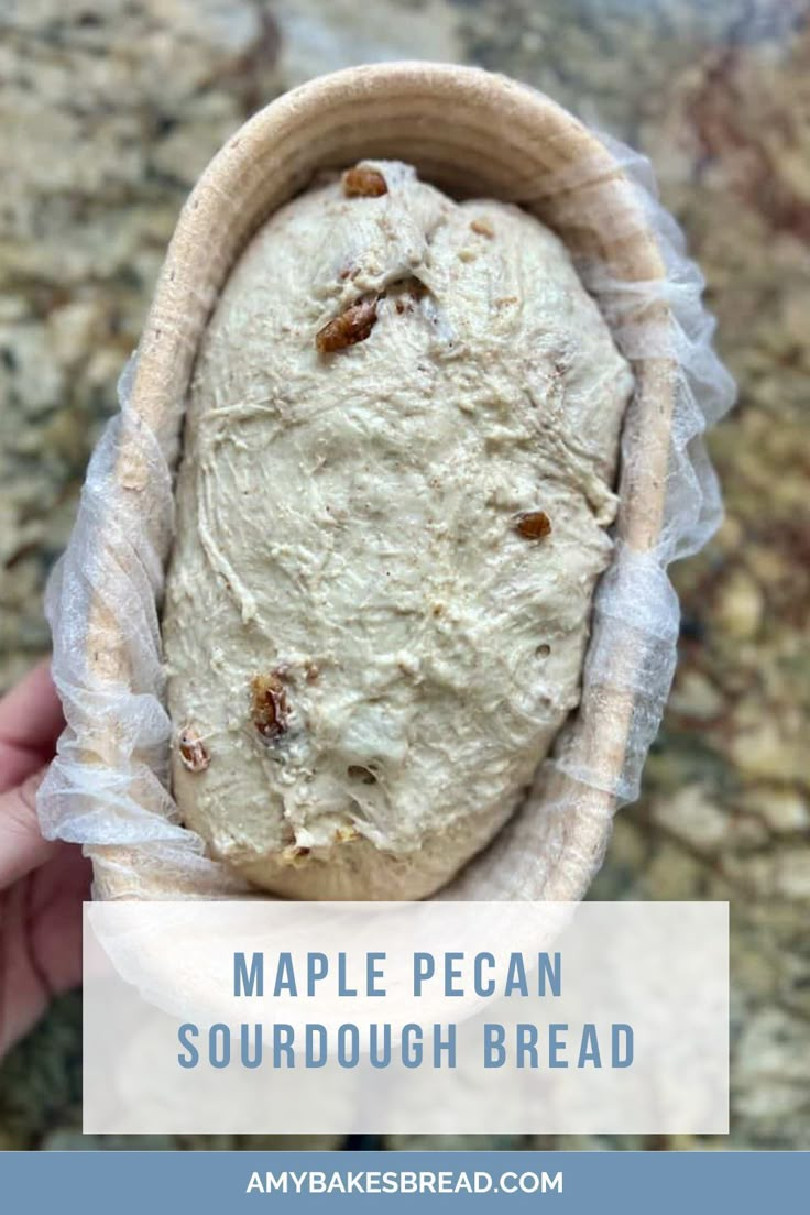 a person holding up a sourdough bread in their hand with text overlay that reads maple pecan sourdough bread