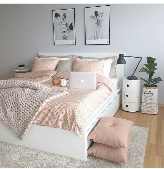 a white bed sitting in a bedroom next to a laptop computer