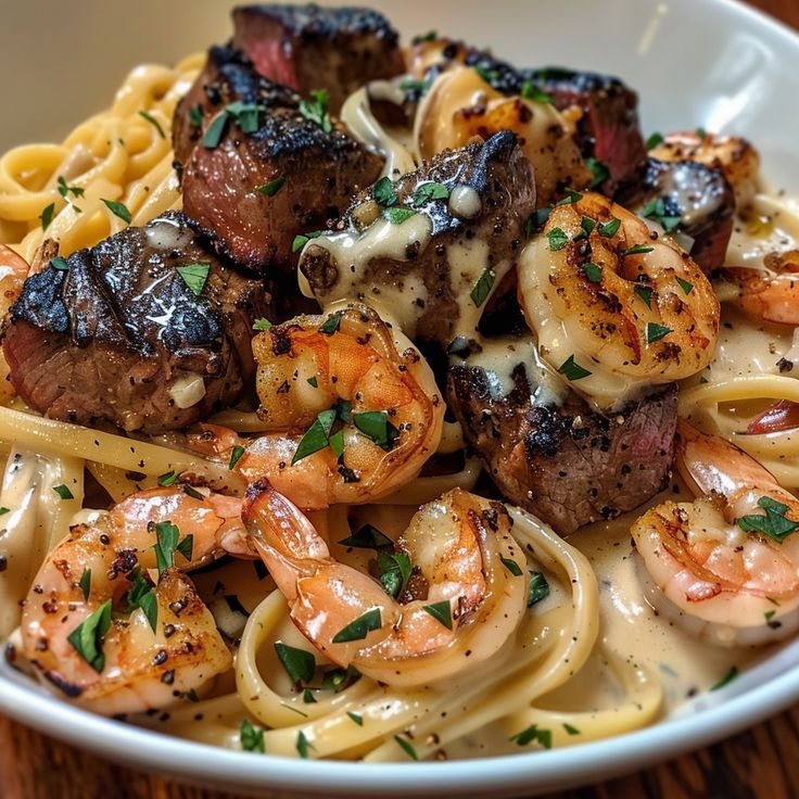 a bowl filled with pasta and shrimp on top of a wooden table next to a fork