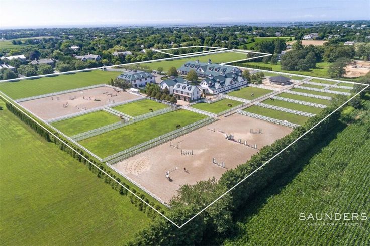 an aerial view of a large field with houses in the background