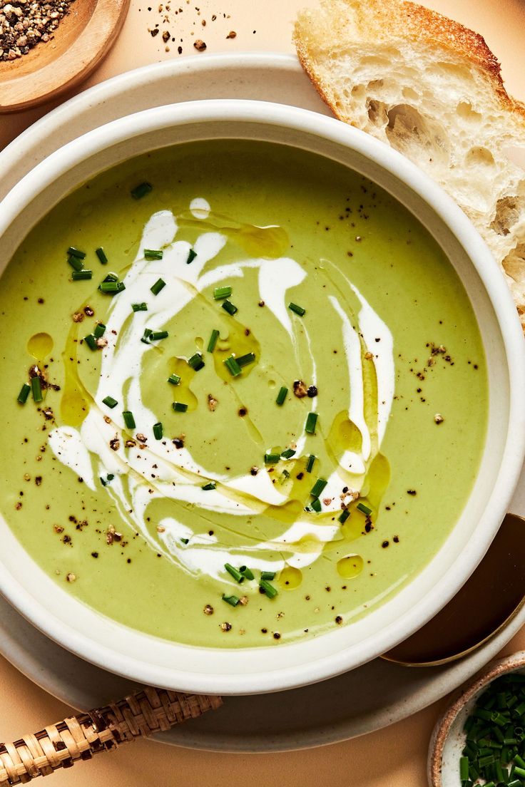 a white bowl filled with soup next to bread