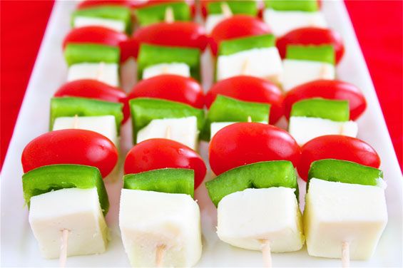 several skewers filled with vegetables and cheese on a white platter, ready to be eaten