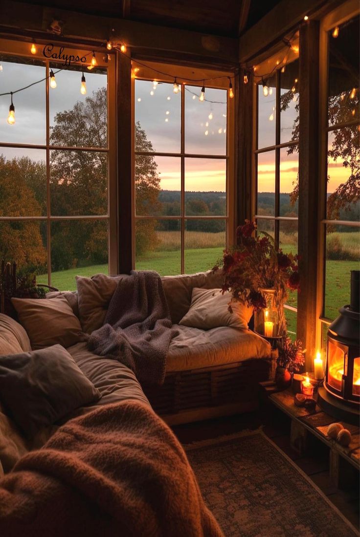 a living room filled with lots of furniture and windows covered in lights next to a fire place