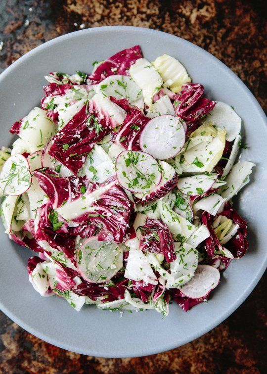 a salad with radishes and cucumbers in a bowl