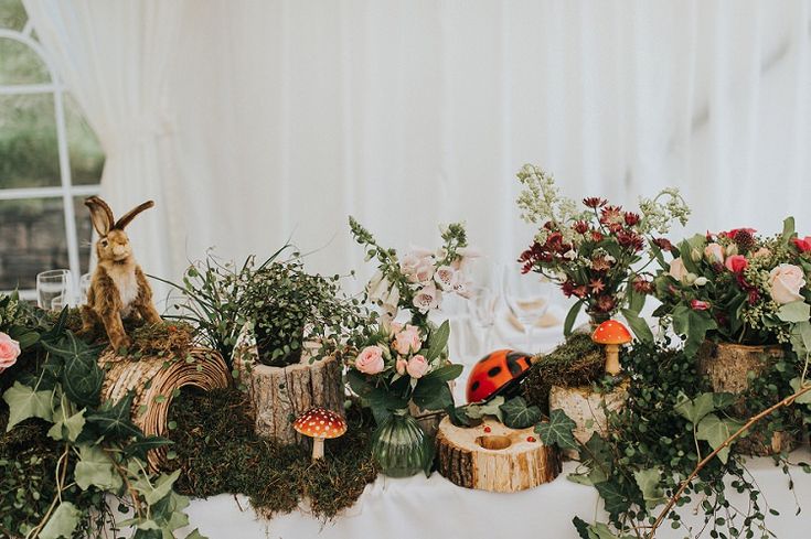 a table topped with lots of plants and flowers