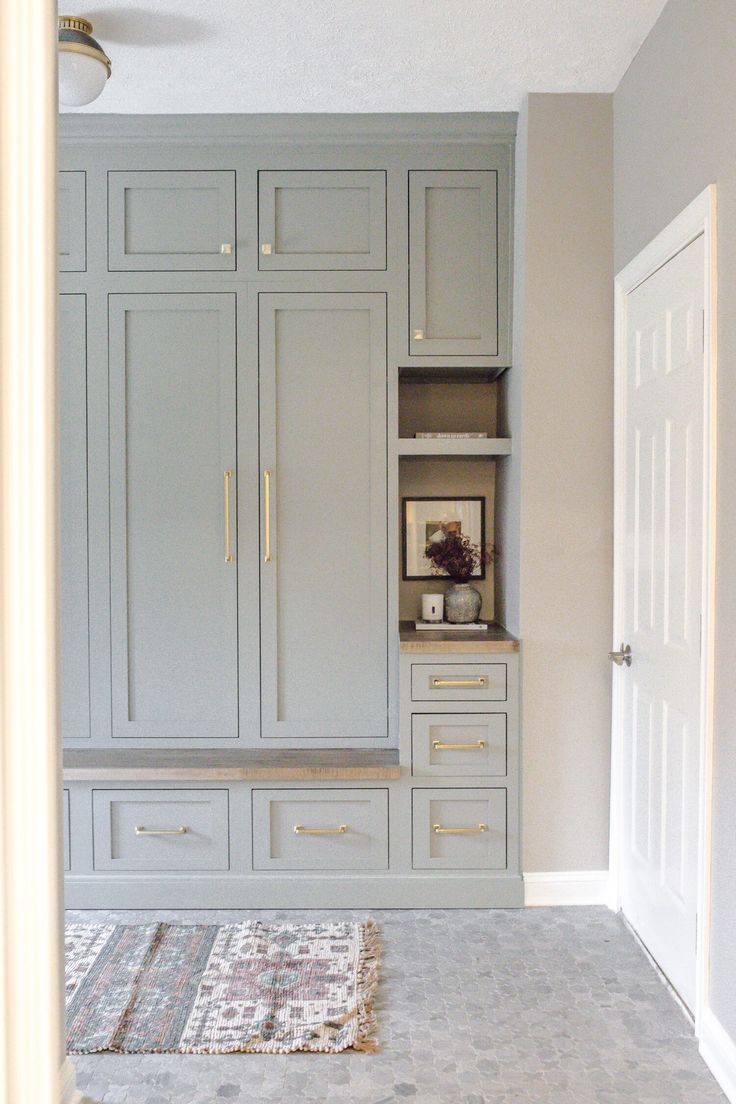 an empty room with gray cabinets and rugs on the floor in front of it