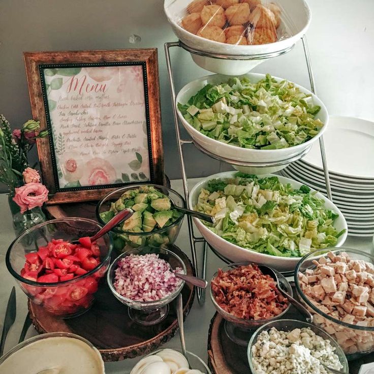 a table topped with lots of different types of salads and bowls filled with vegetables