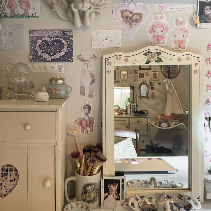 a dresser and mirror in a room with pictures on the wall