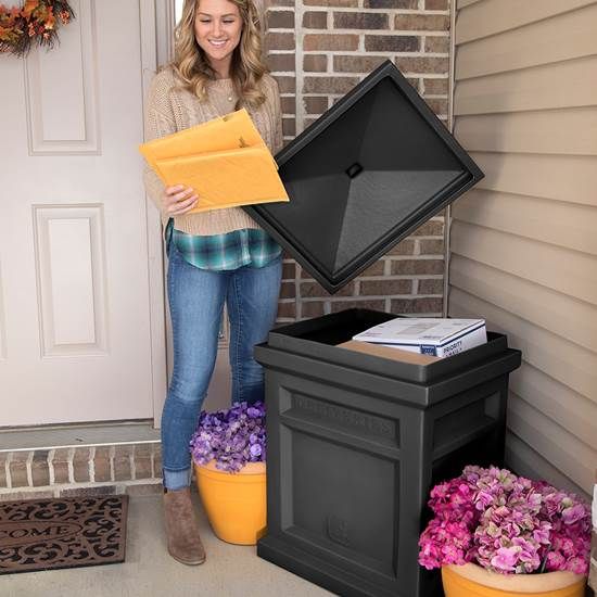 a woman standing in front of a mailbox with an open box next to it