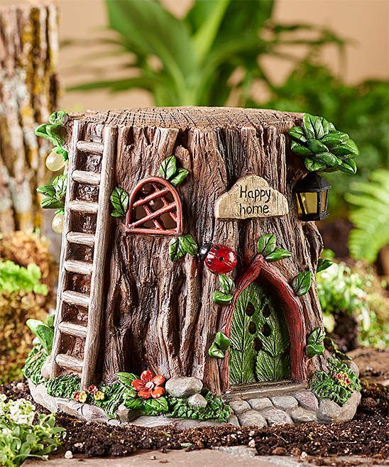 a fairy garden with a tree house and ladder