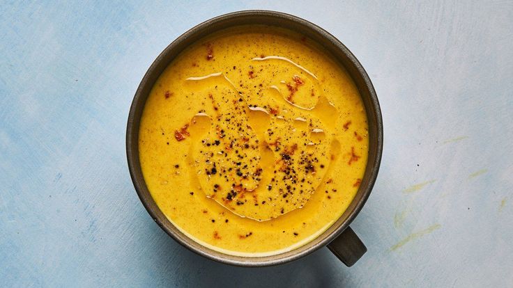 a bowl filled with soup sitting on top of a blue table