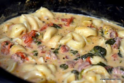 pasta with spinach and tomato sauce in a skillet