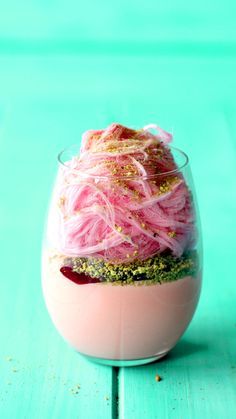 a dessert in a glass with pink and gold sprinkles on the top