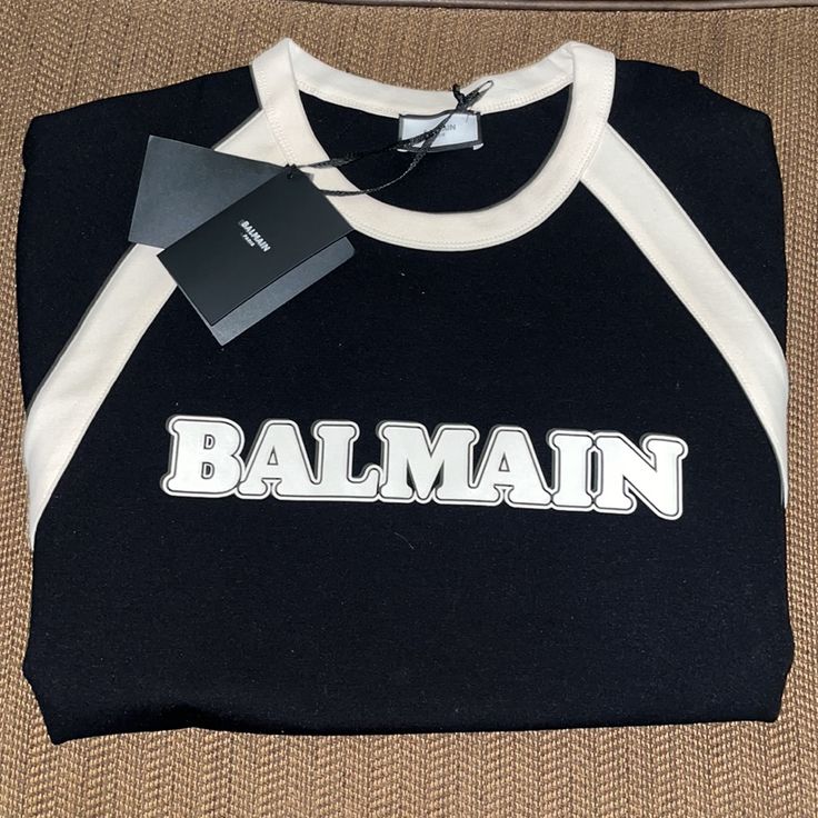 New With Tags Balmain T-Shirt With Logo Authentic Men’s Brand New/ No Defects Quantity Available (1) See Photos For Exact Item Detail Color: Black, White Size: L Details: Black T-Shirt From Balmain. Crafted From Lenzingecovero, This Design Features A White Logo Print And Ribbed Crew Neck In Cream. 63% Lenzingecovero Viscose 31% Polyamide 6% Elastane Imported No Exchanges No Returns No Buyers Remorse No Low Ball Offers We Waive All Liability Of All Purchased Items Once In The Possession Of The Ma Black Short Sleeve Top With Logo, Luxury Black T-shirt With Letter Print, Designer Black T-shirt With Monogram Print, Luxury Monogram Print Crew Neck T-shirt, Black Logo Tops For Streetwear, Luxury Crew Neck Top For Streetwear, Black Tops With Logo Detail For Streetwear, Luxury Black T-shirt For Streetwear, Black Long Sleeve Tops With Logo