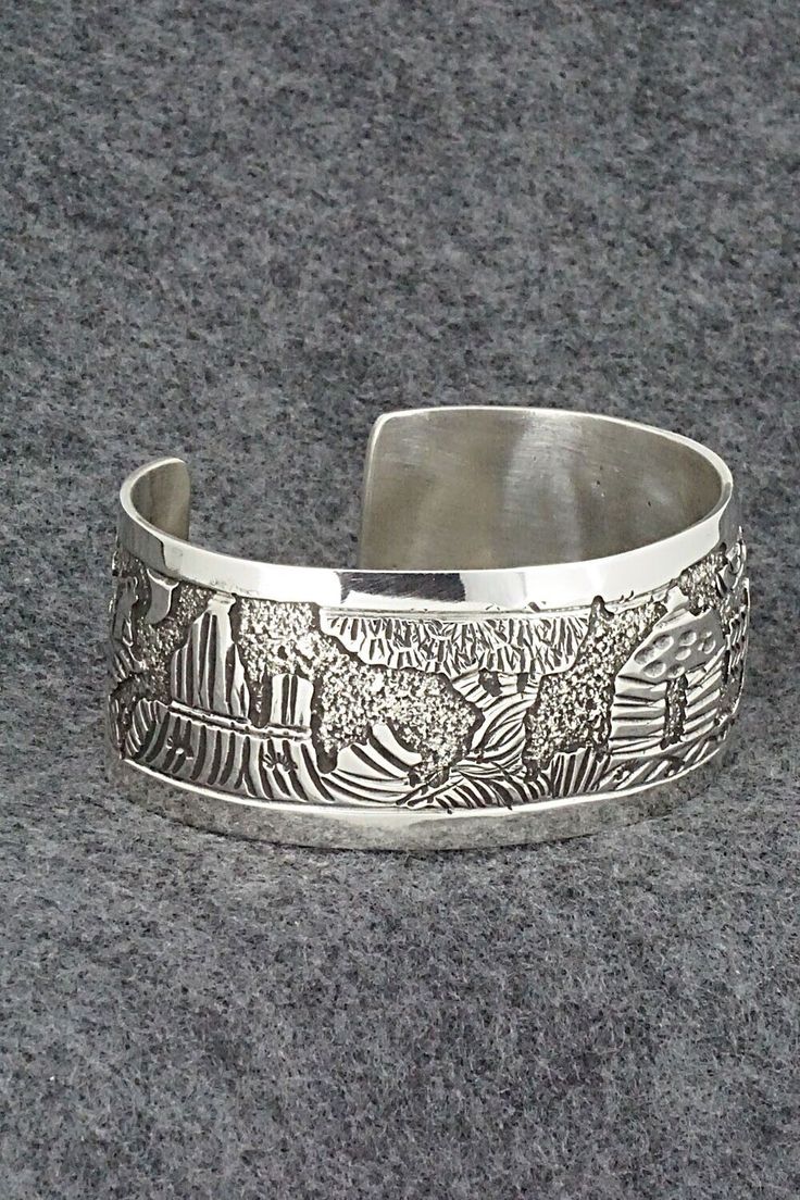 This amazing sterling silver bracelet featuring detailed Southwest scenery including a Navajo hogan, howling coyote, horse cart and rock formations was made by Navajo silversmith Elaine Becenti. The inside is signed B and stamped sterling.Size: 5 3/4" (will fit up to a 6 3/4" wrist)Gap: 1"Width: 1"Free shipping on all orders! We ship with USPS and always include tracking. All orders ship within a day of payment.Returns are accepted up to 30 days after you receive your order. Just send us a messa Carved Sterling Silver Bracelet, Carved Sterling Silver Bracelets, Engraved Sterling Silver Bohemian Bracelet, Artisan Sterling Silver Bracelet, Bohemian Sterling Silver Engraved Bracelet, Collectible Artisan Bracelet With Engraved Details, Artisan Engraved Bracelet For Collectors, Artisan Collectible Bracelet With Engraved Details, Artisan Engraved Bracelet Collectible