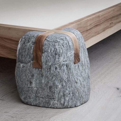 a grey rock sitting on top of a wooden floor