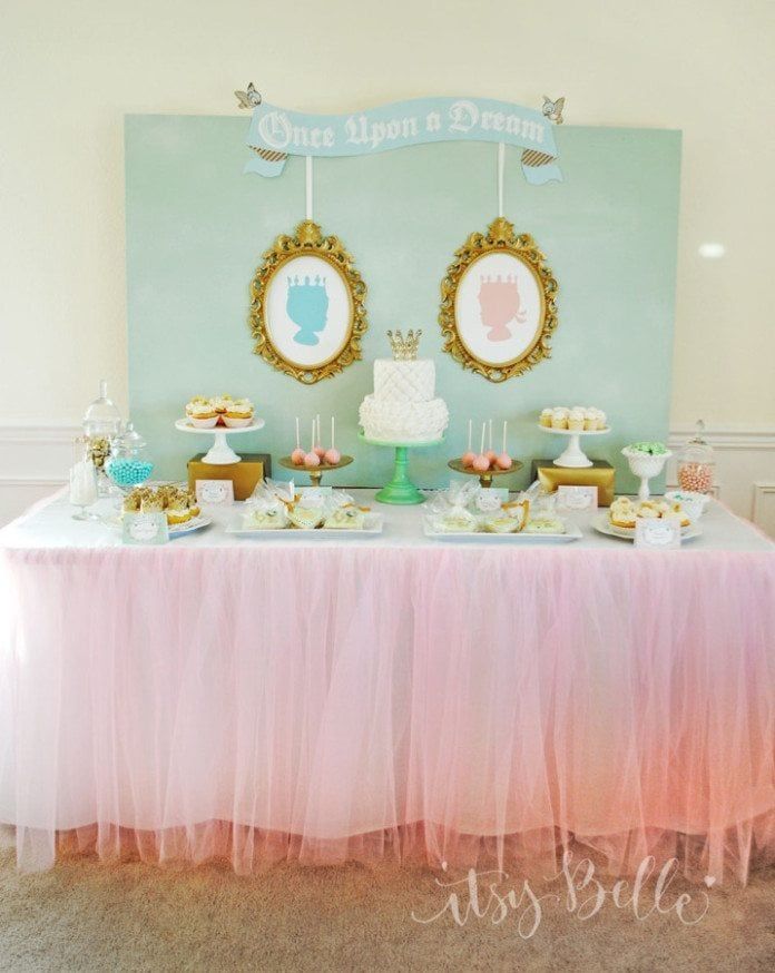 a table topped with cake and cupcakes next to a wall