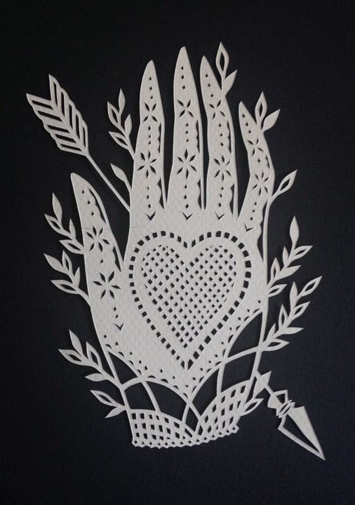 a paper cutout of a hand holding a heart surrounded by leaves and arrows on a black background