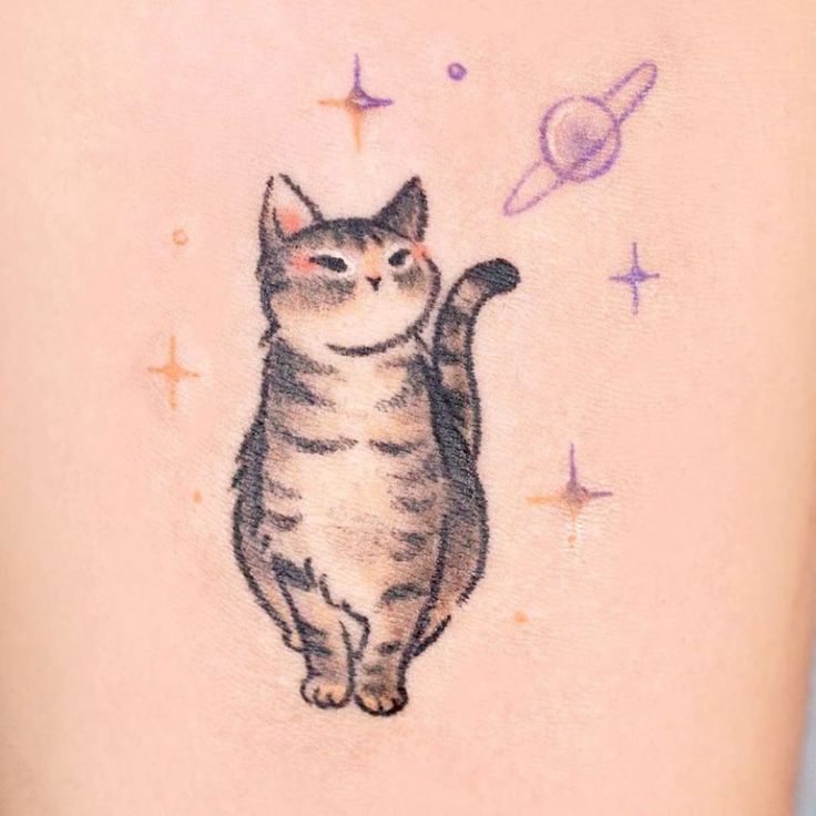 a cat tattoo on the back of a woman's leg with saturn in the background