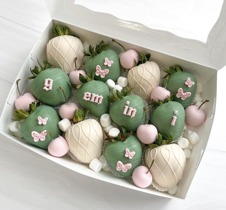 a box filled with green and white chocolate covered strawberries