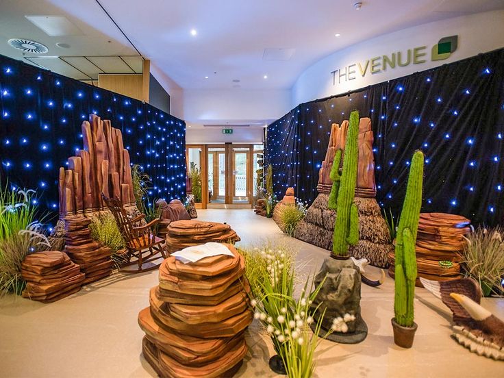 an indoor garden with plants and rocks in the center, surrounded by blue lights on the walls