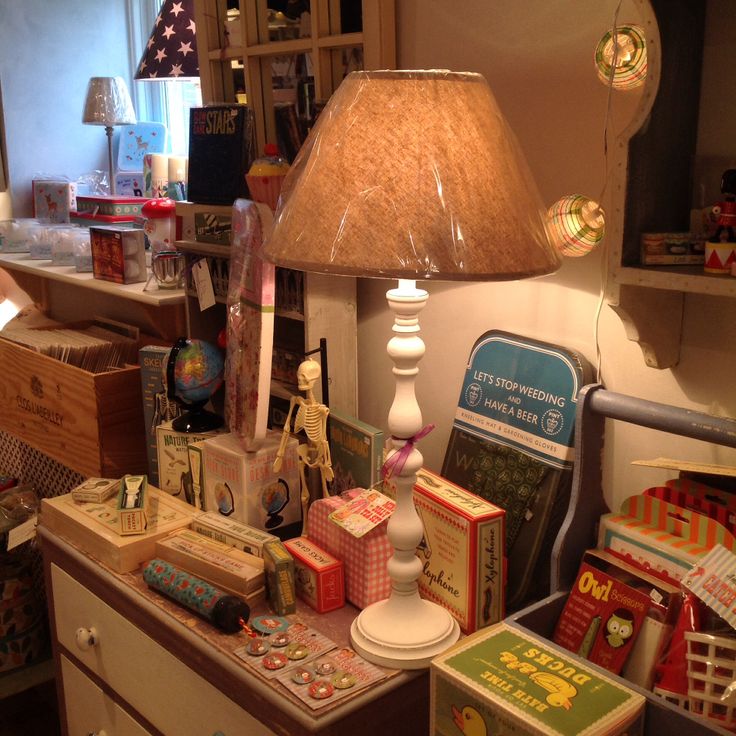 a lamp sitting on top of a wooden table next to boxes and other items in a room