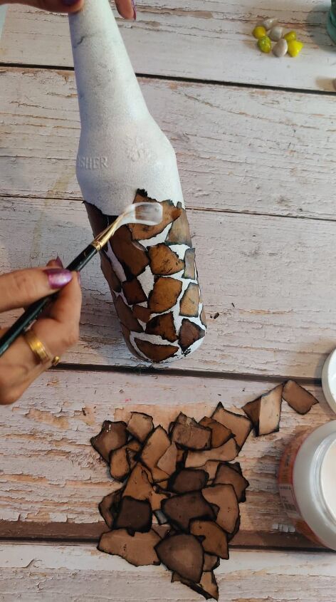 someone is painting a vase with brown and white paint