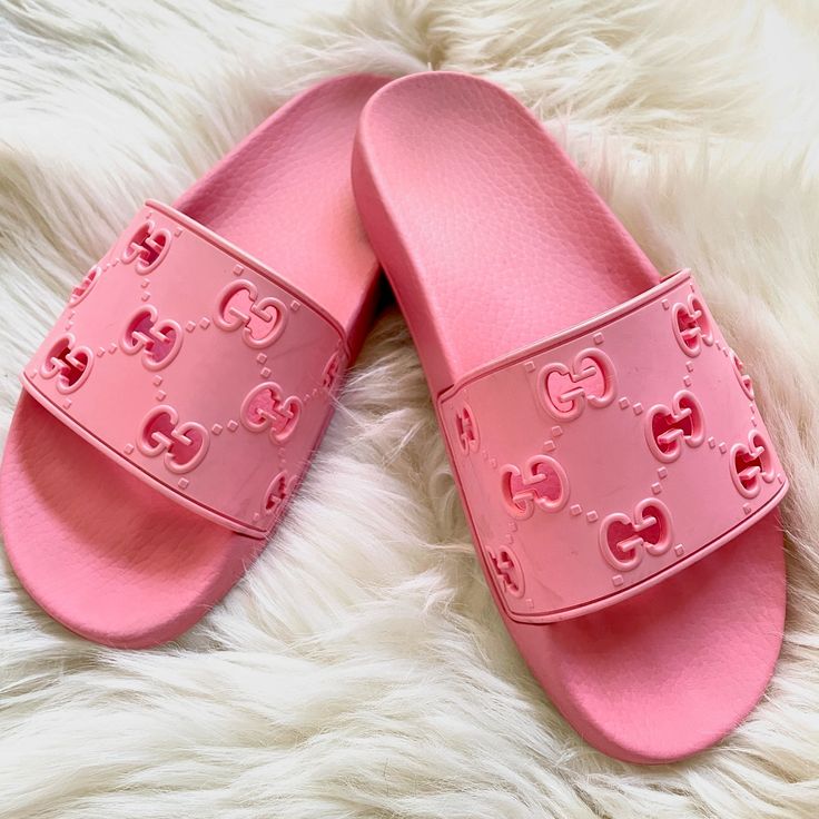 a pair of pink slippers with hearts on them sitting on a white fur rug