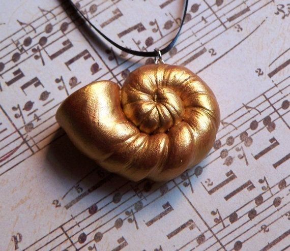 a necklace with a gold shell on top of sheet music