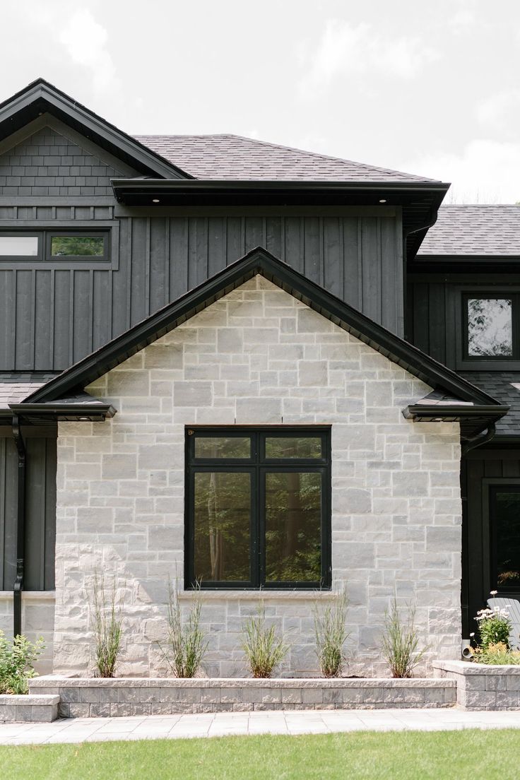 the front of a house with black trim and windows