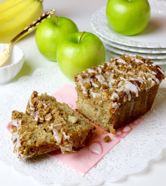 two pieces of cake sitting on top of a pink napkin next to some green apples