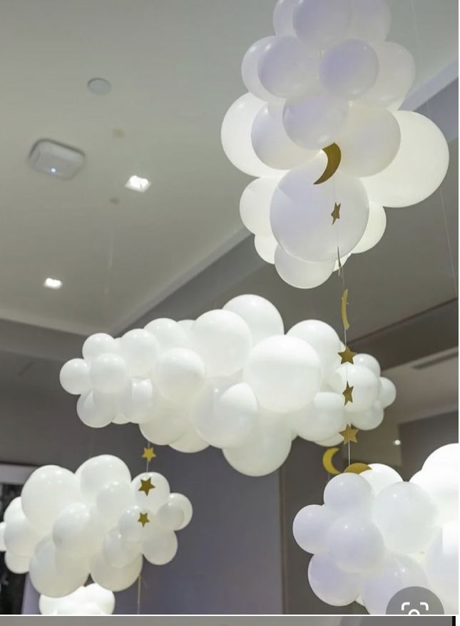 white balloons with stars and moon hanging from the ceiling